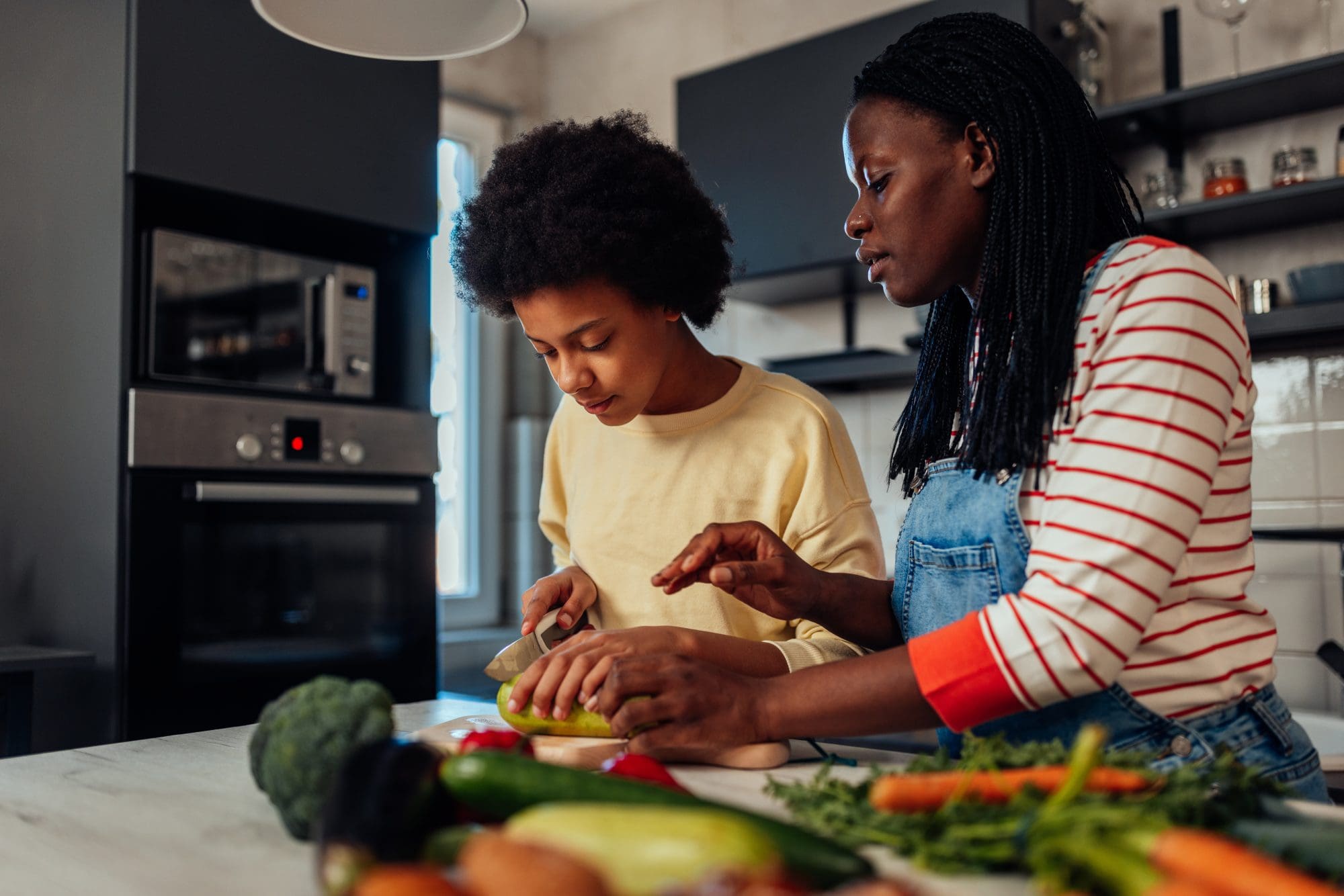 Teen with mental health challenges practices nutritional awareness by cooking with parent. 